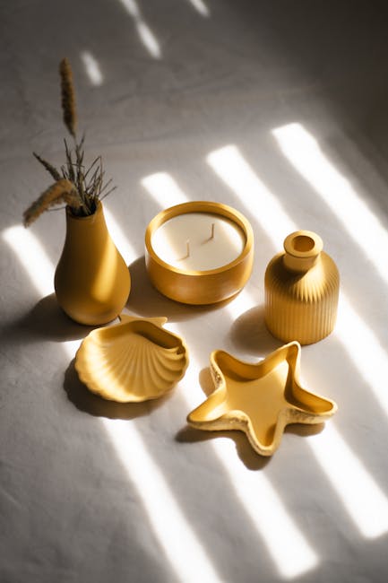 Aesthetic setup of yellow ceramics and candle in natural light, perfect for home decor inspiration.